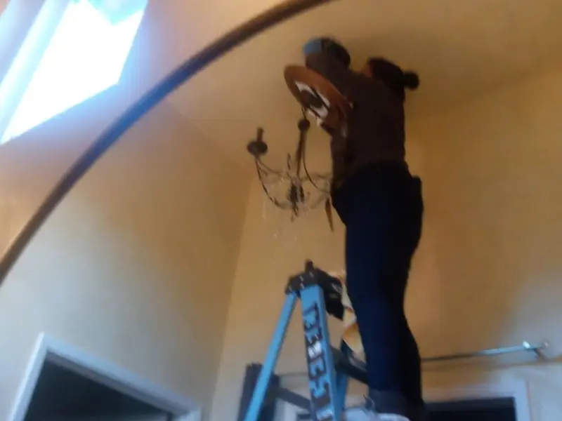 Electrician installing a chandelier in a El Mirage residence